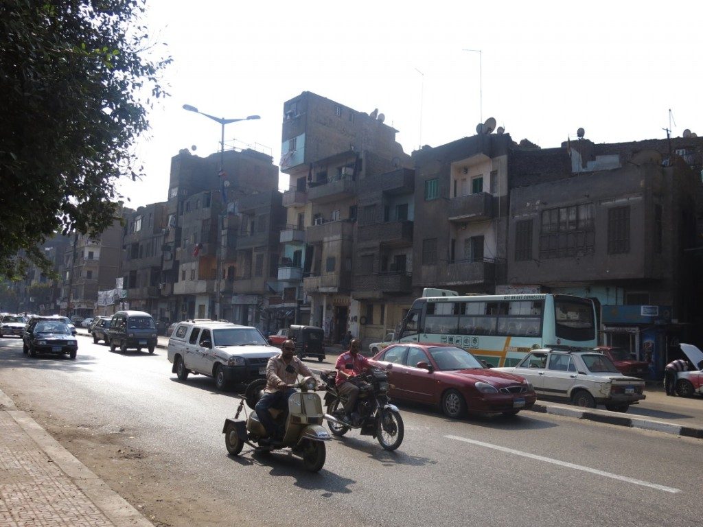 The Nile corniche from the Kīt Kāt direction has modest residential houses a few stories high, contrary to many other areas where the waterfront is invaded by high rise towers. On the ground floors are grocery stores, car repair workshops and simple crafts shops. (Tadamun, 2015)